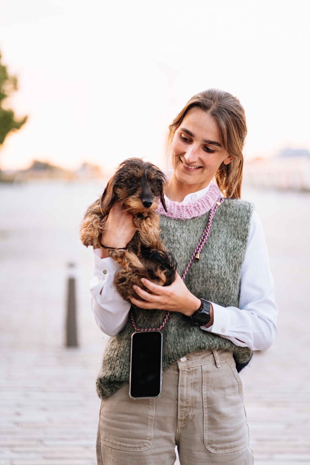 Een vrouw die een puppy in haar armen draagt.